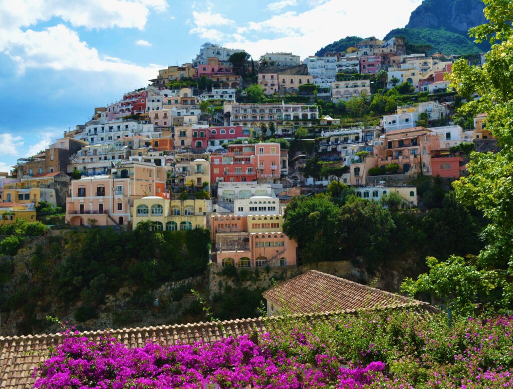 pexels photo 919280 919280 Vibrant houses built along the cliffside in Positano, Italy, surrounded by lush greenery and flowers.